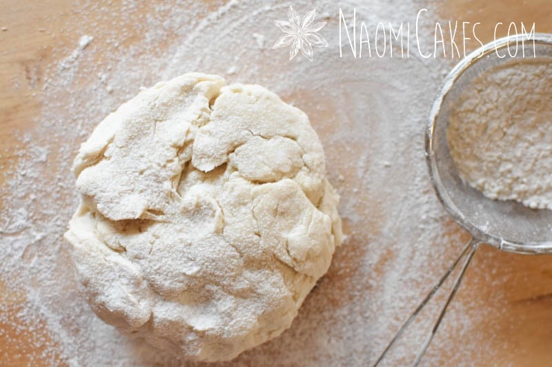 pastry dough and a sieve on a wooden board