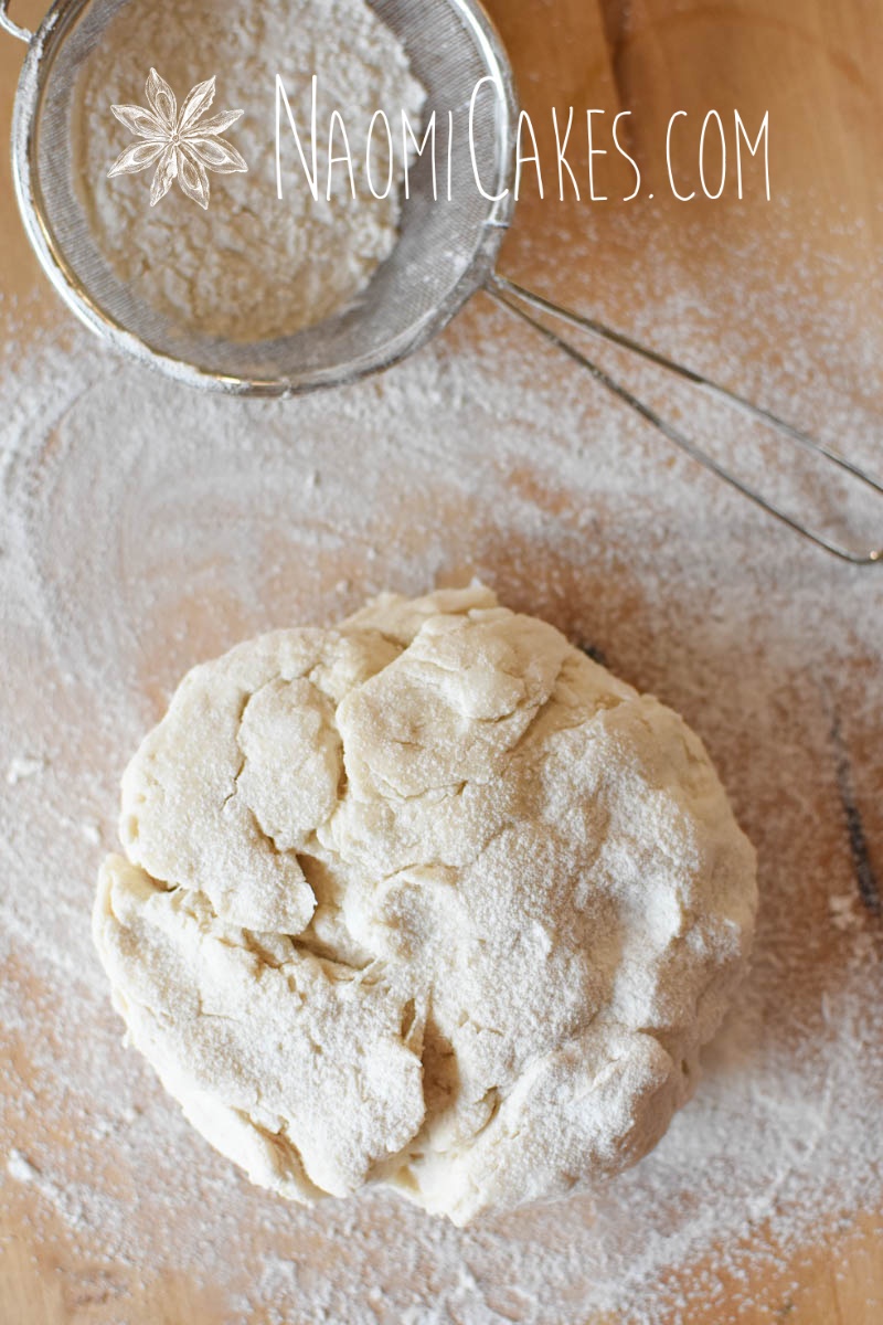 pastry dough and a sieve on a wooden board