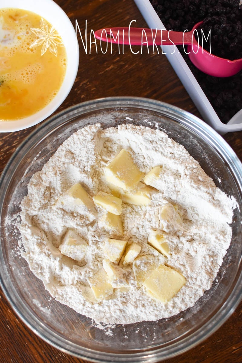 chunks of cold butter in flour with other baking ingredients beside it