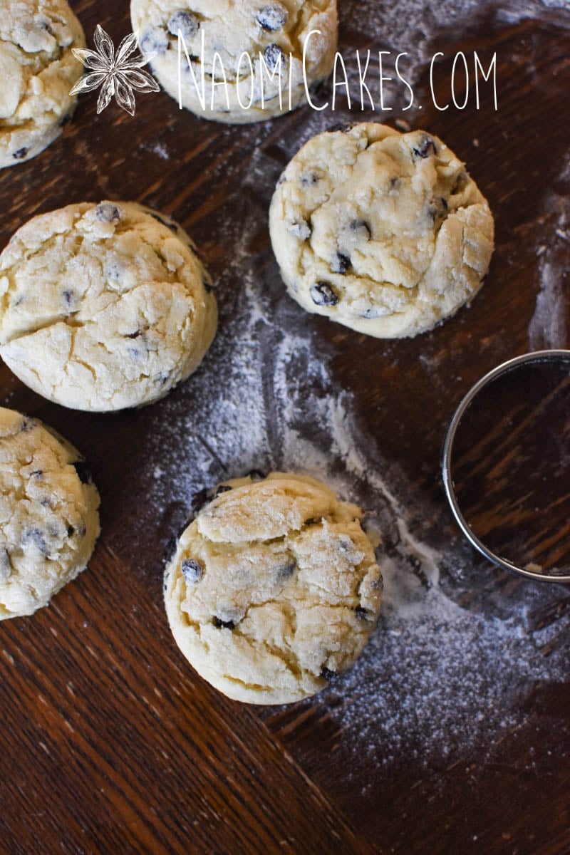 6 cut out currant scones with a biscuit cutter on a wooden table