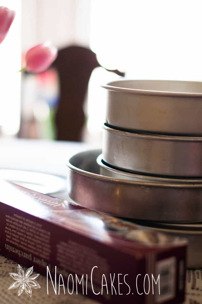 cake decorating pans and a roll of parchment paper on a table