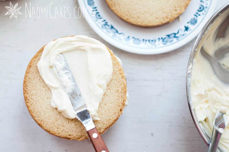 spreading frosting on a round cake overhead view