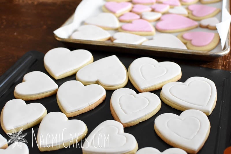 white heart shaped cookies with pink ones in the background