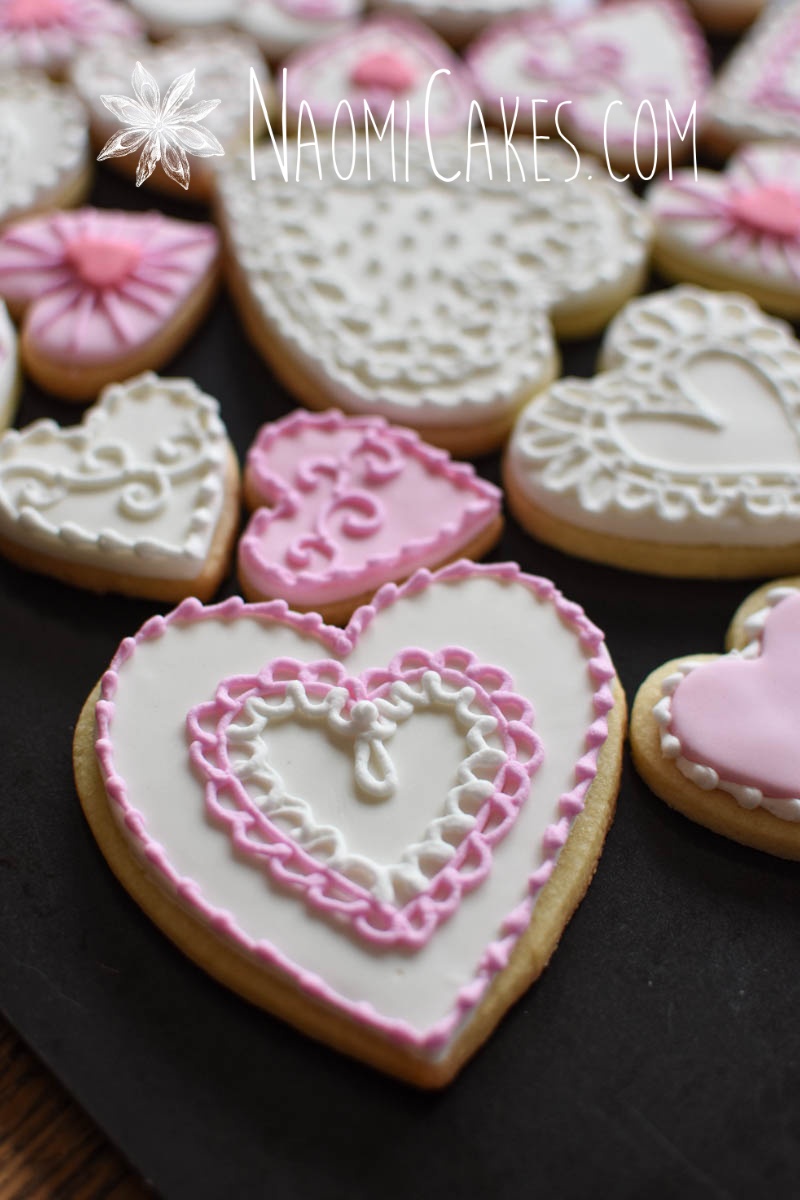 Frilly lace pink and white heart cookies for Valentines Day on a black pan