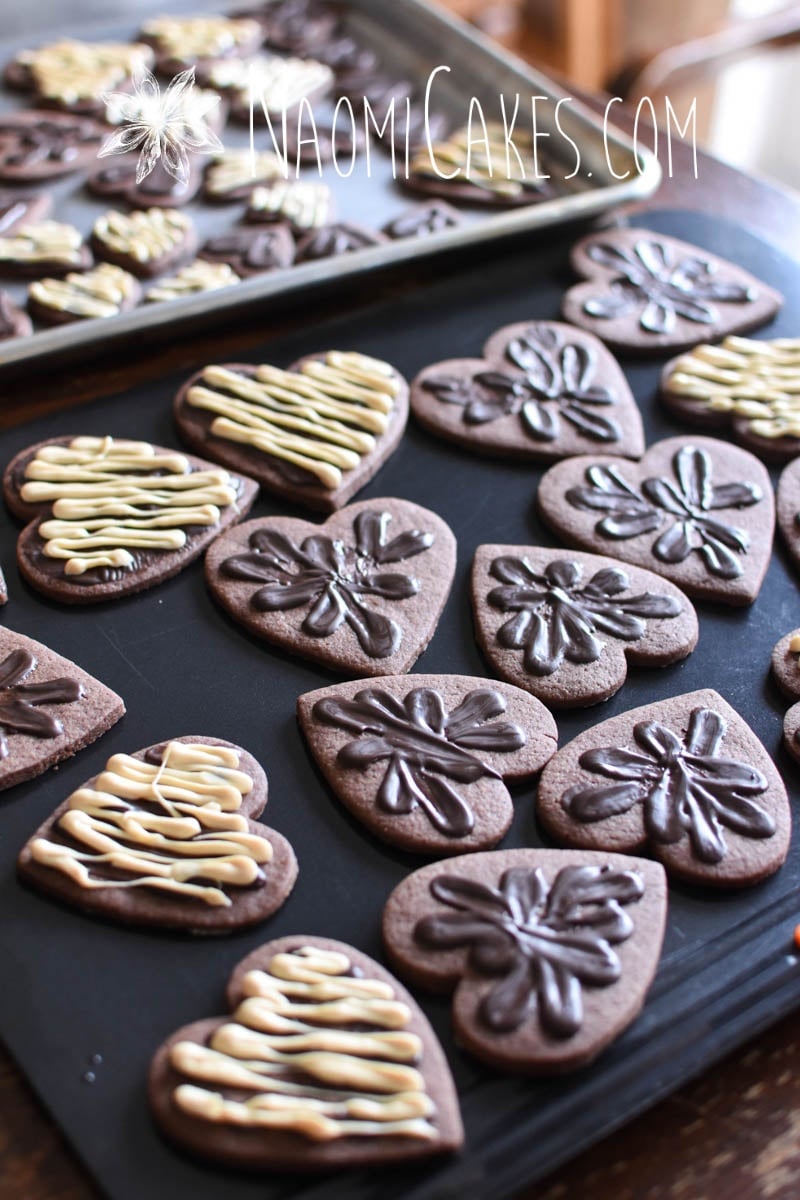 chocolate heart shaped sugar cookies with chocolate decoration on cookie sheets