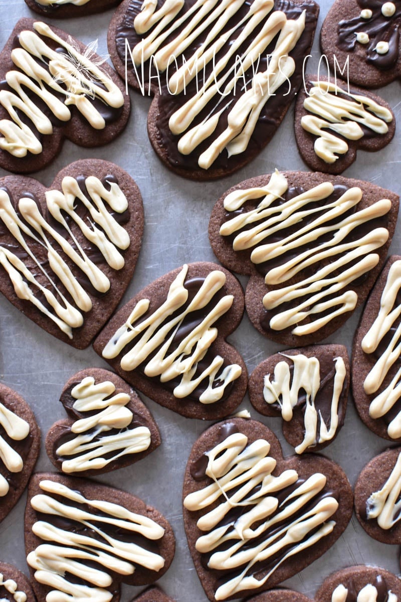 overheard view of chocolate heart shaped sugar cookies with white and dark chocolate drizzled on top