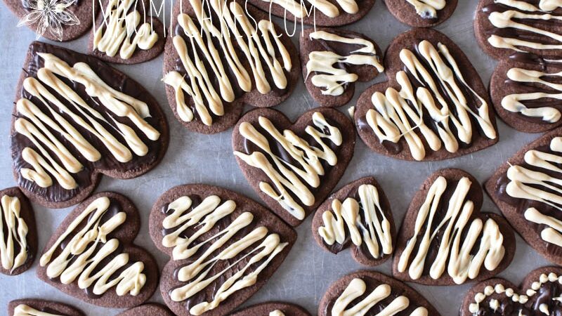 overheard view of chocolate heart shaped sugar cookies with white and dark chocolate drizzled on top