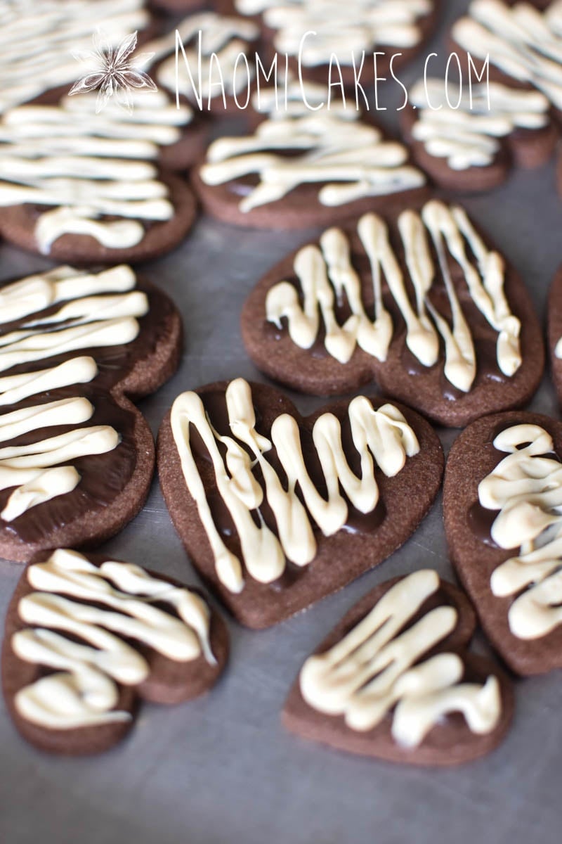 angle view of chocolate heart shaped sugar cookies with white and dark chocolate drizzled on top