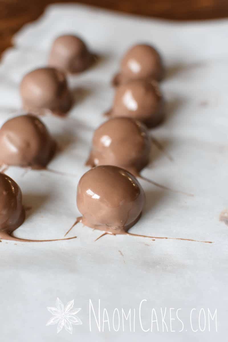 freshly dipped milk chocolate truffles on parchment paper