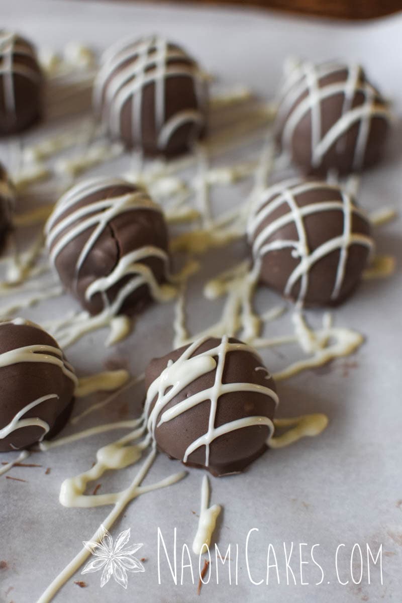 truffles drizzled with white chocolate on parchment paper
