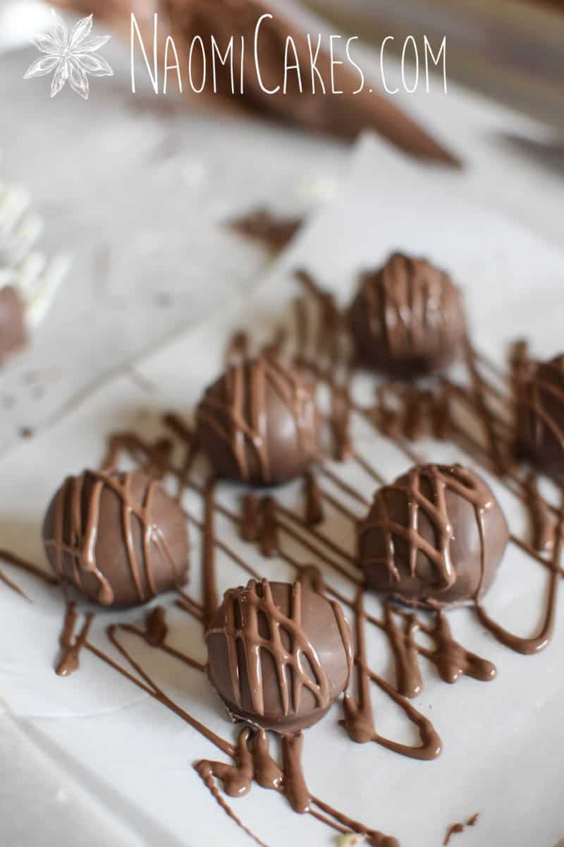 milk chocolate drizzled truffles on parchment paper