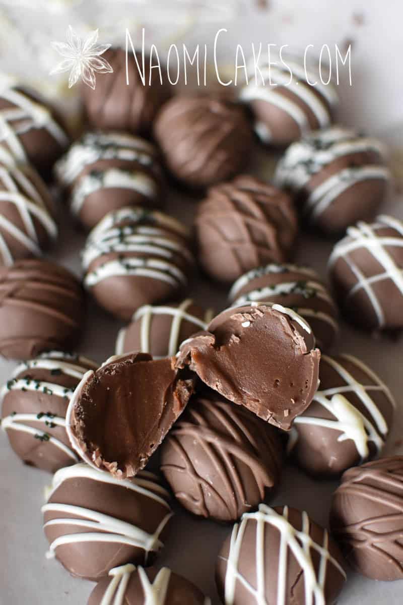 a cut open milk chocolate truffle laying on top of rows of other truffles