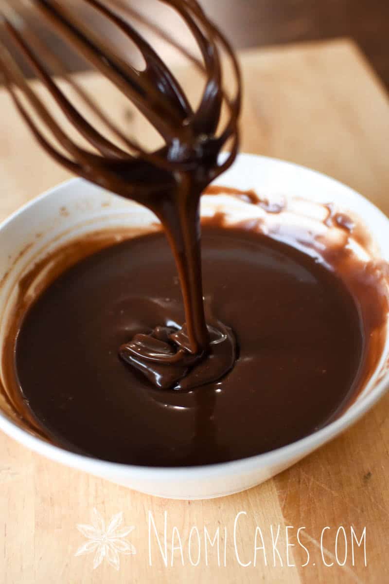 a whisk lifting out of freshly made milk chocolate ganache