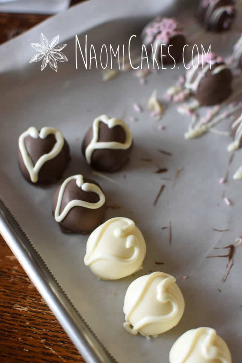 white and milk chocolate coated truffles on parchment paper