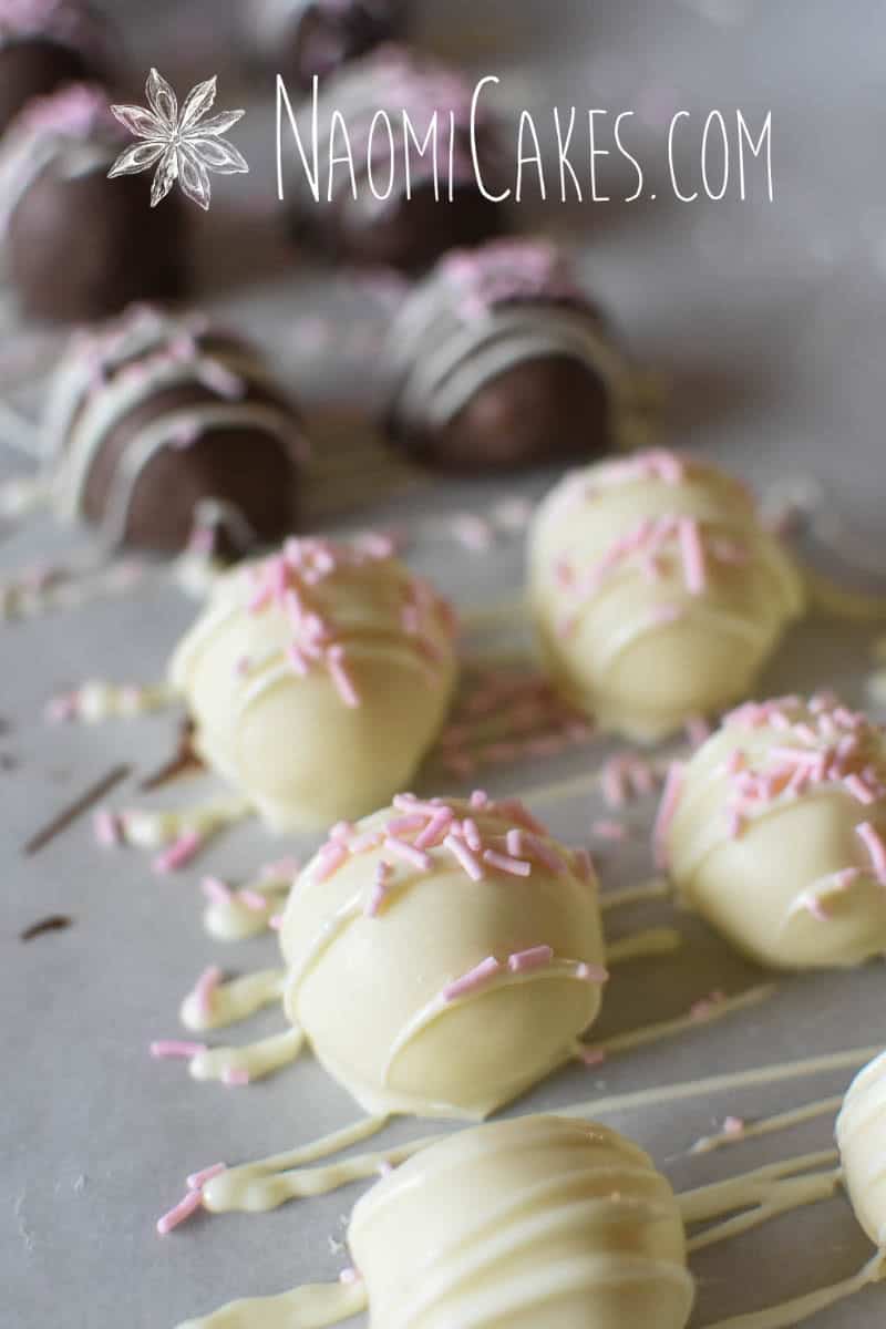 white and milk chocolate coated truffles on parchment paper