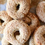 a pile of sesame sourdough bagels