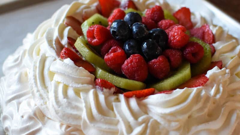 creamy custard pavlova with fruit and berries