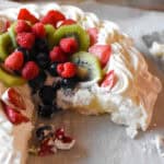 custard pavlova with assorted fruit and berries, cut open