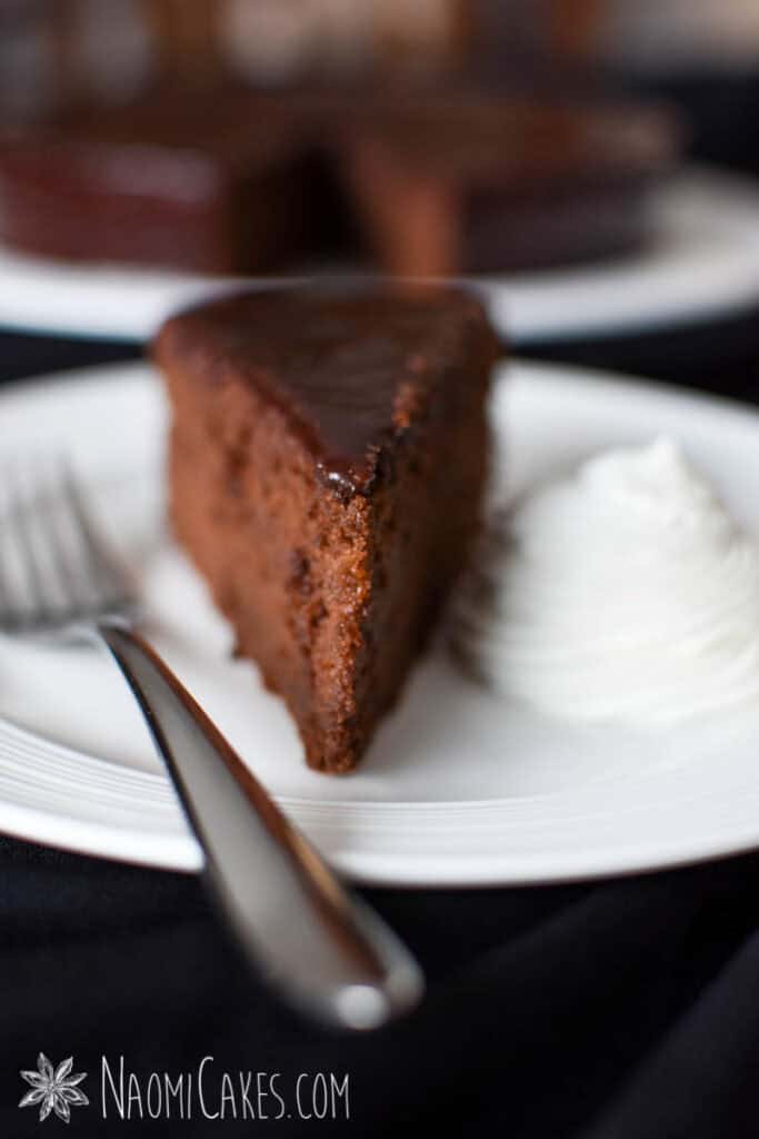 a plate with Sachertorte and whipped cream with a fork