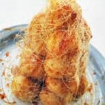 croquembouche tower on a blue rimmed plate with spun sugar