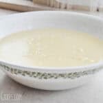 bowl of vanilla pudding on a wooden table