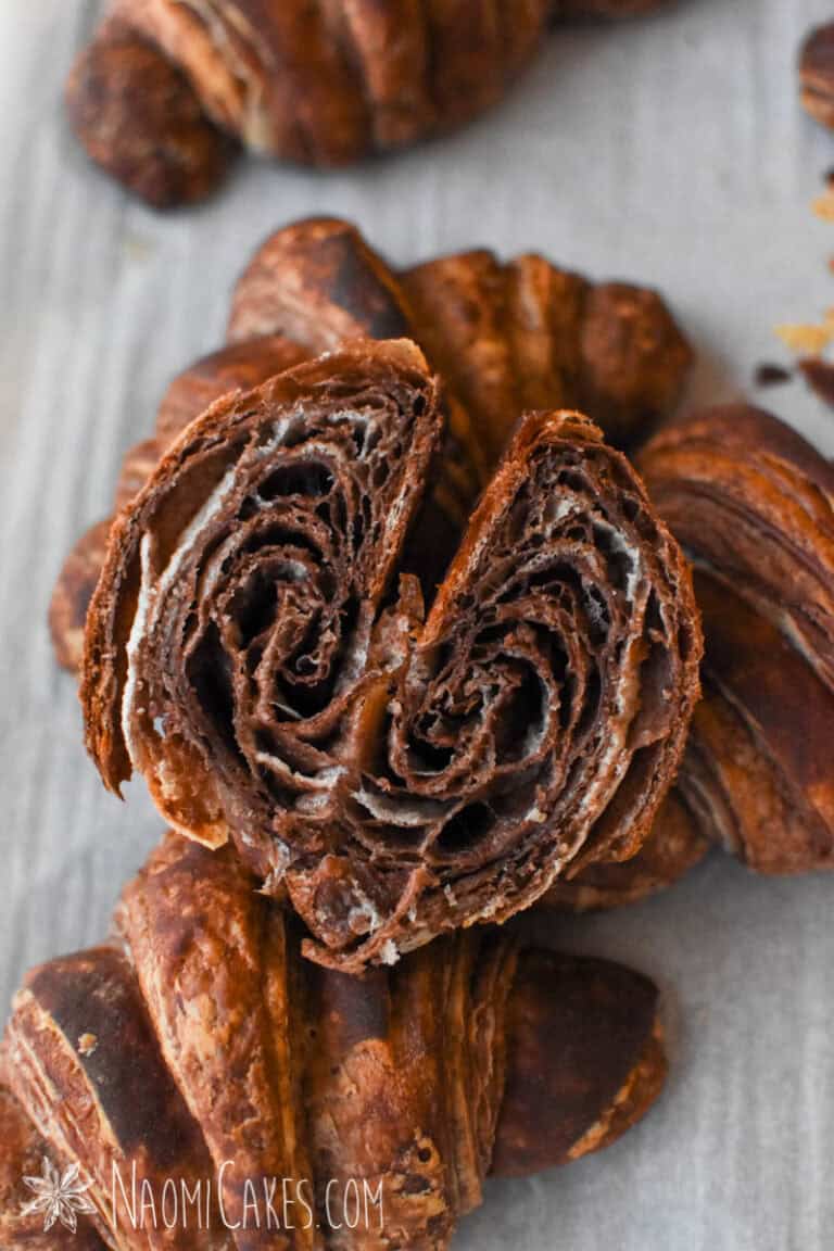 a chocolate croissant cut in half on top of other croissants
