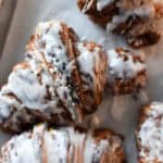 chocolate croissants with icing on a cookie sheet