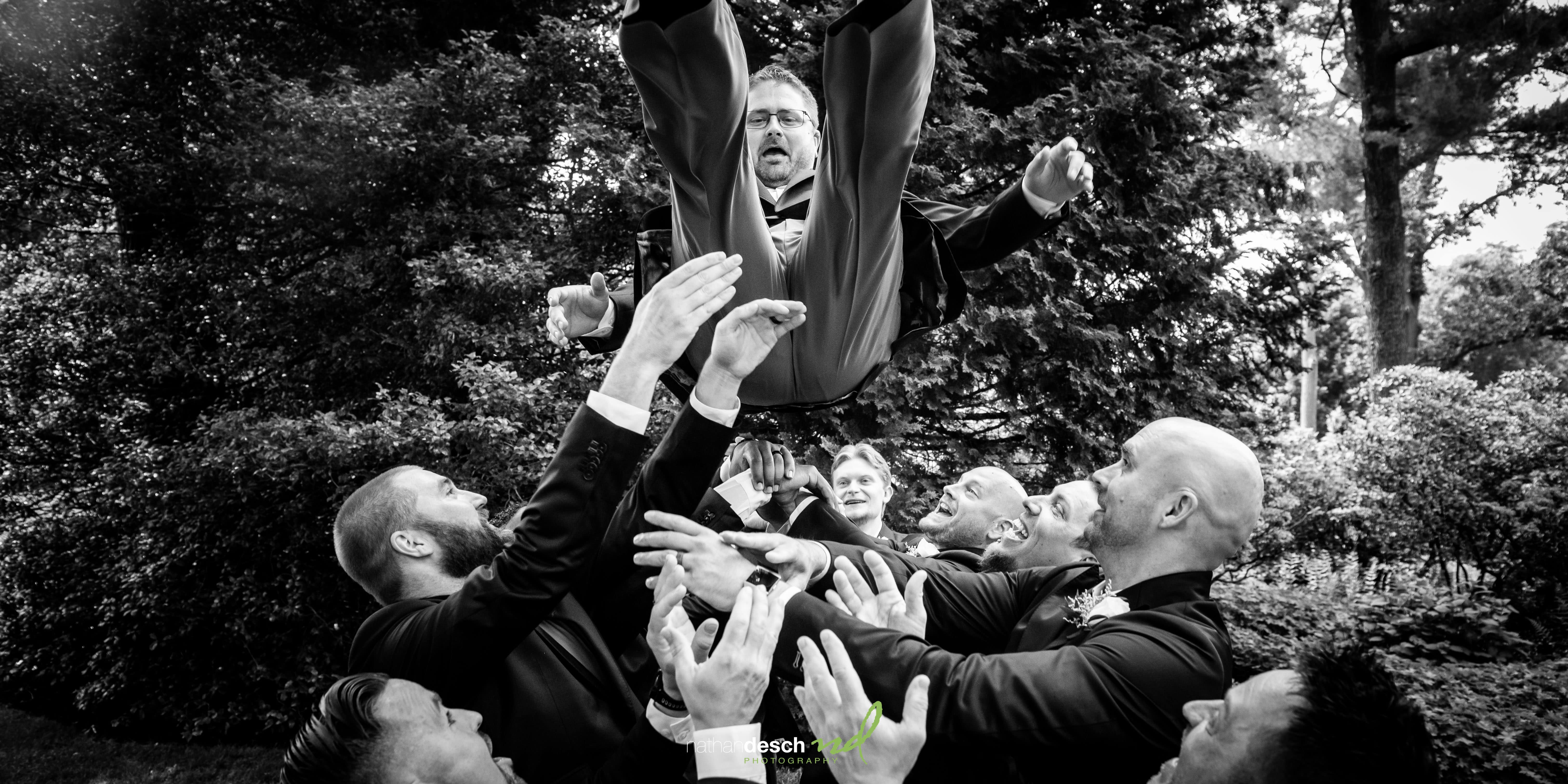 groomsmen tossing groom