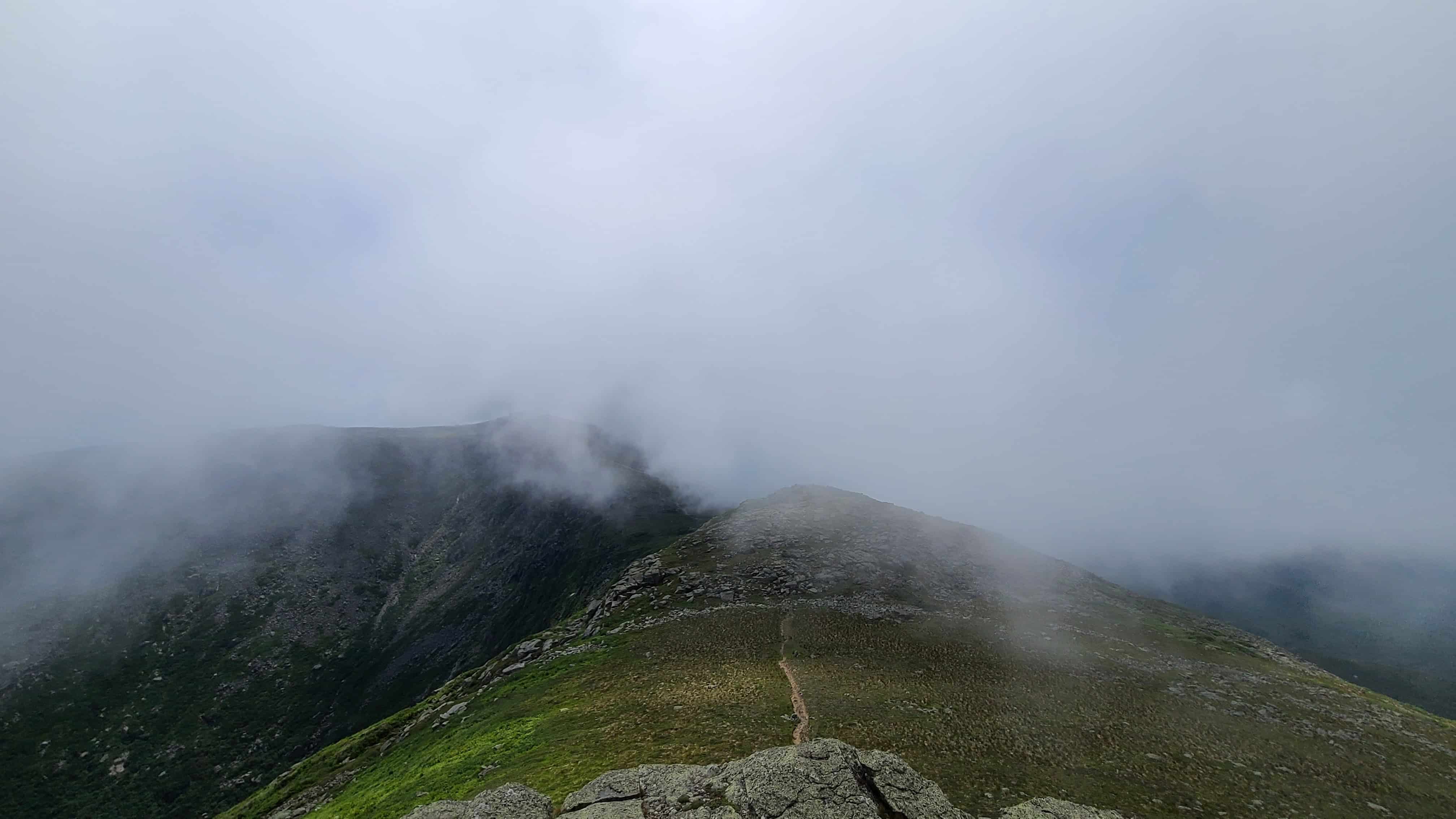 Misty Presidential Traverse mountain ridge, winding trail, lush grass—scenic adventure wedding spot in the White Mountains.