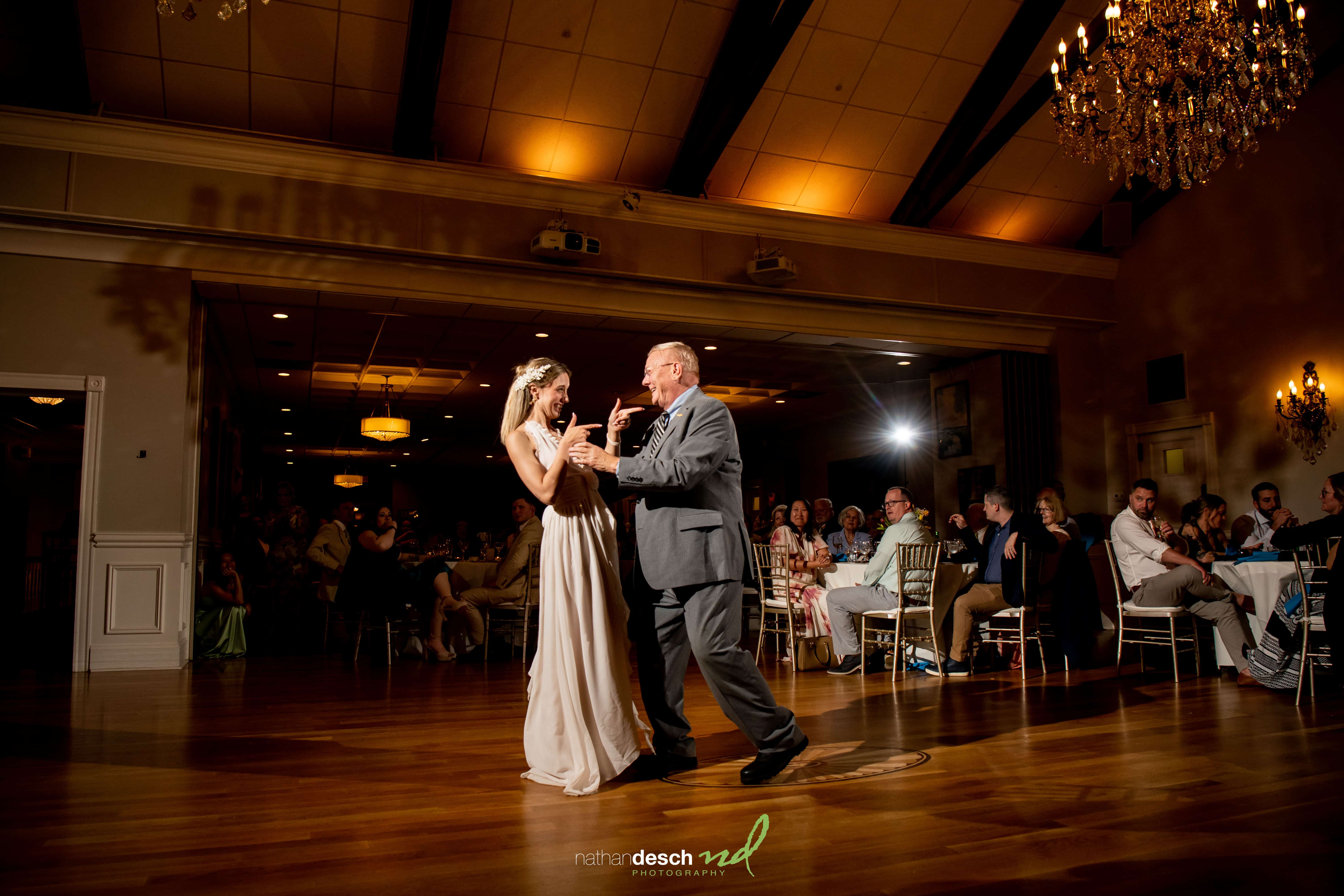 Bride and father dance at University and Whist Club wedding reception as guests and photographers capture the joyful moment.