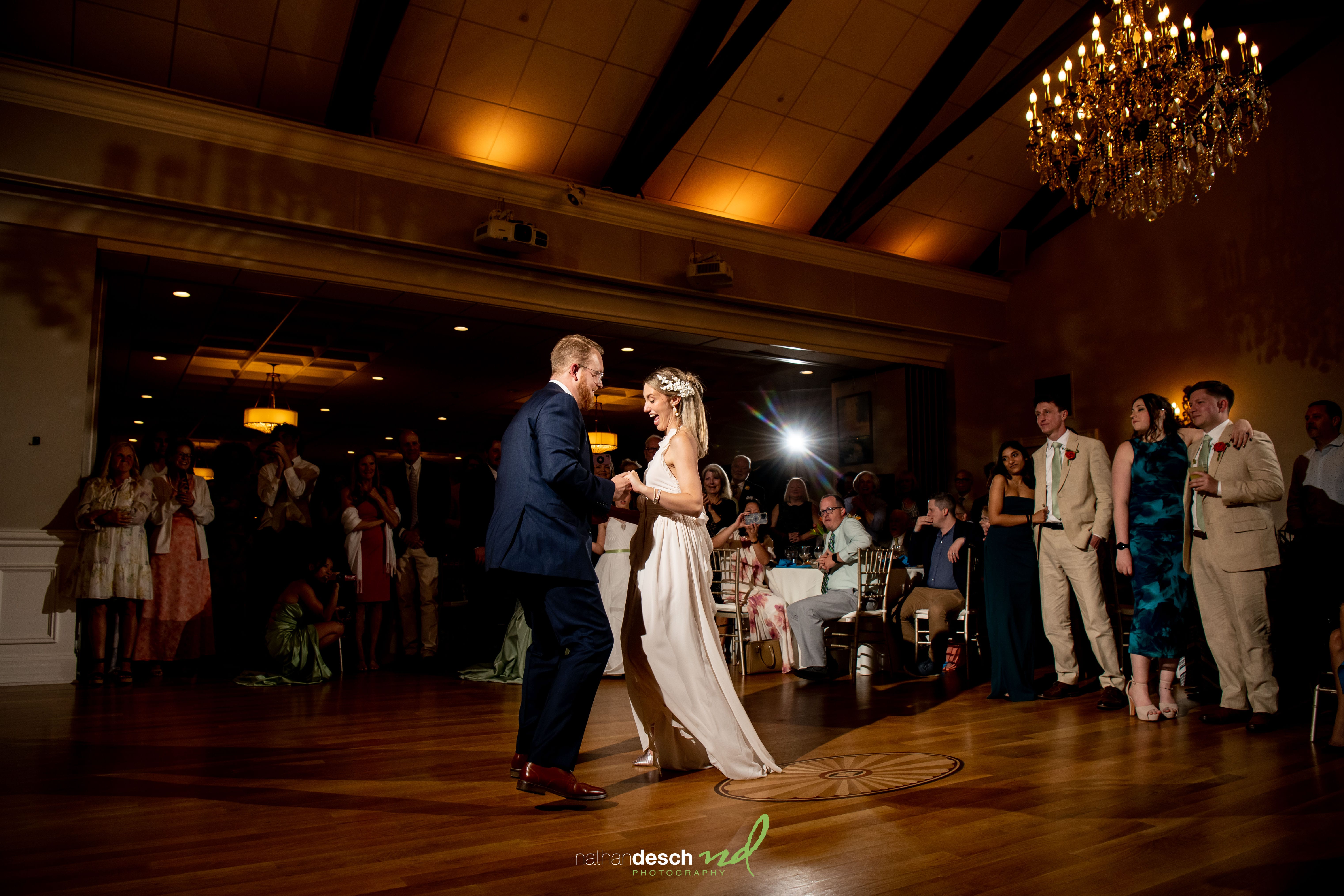 Bride and groom, Garrett and Ashley, share a first dance at their University and Whist Club wedding under chandelier light.