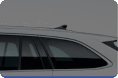 Partial view of a white car, focusing on the rear side window, roof, and a small roof fin against a plain gray background.