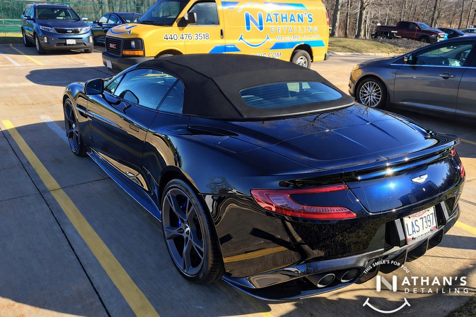 Black convertible rear view parking lot during mobile detailing