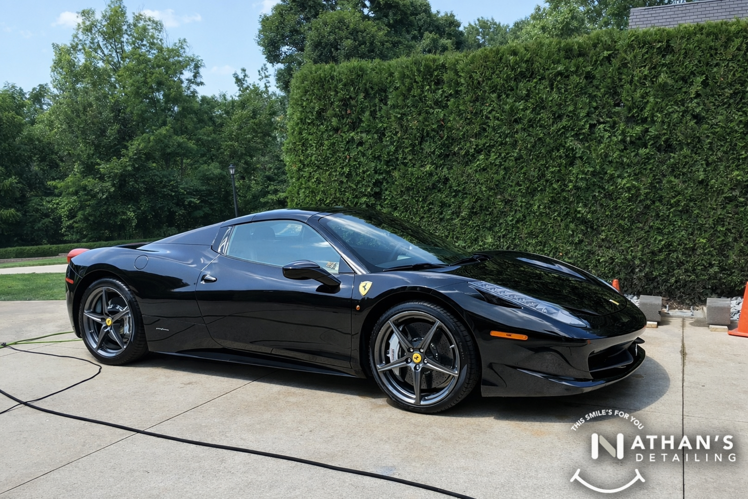 Black ferrari shiny side profile driveway during mobile detailing