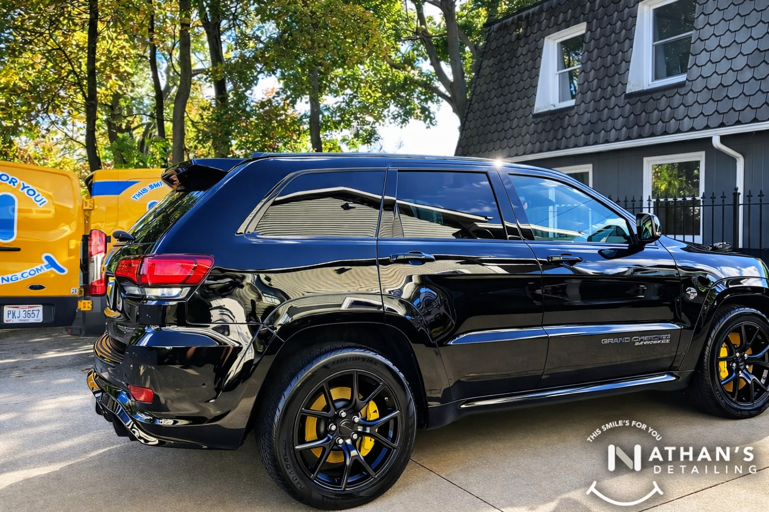 Black suv cleaned side profile with van during mobile detailing