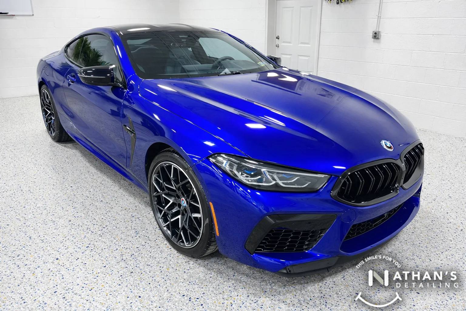 Blue BMW coupe parked in our bay after paint protection film install.