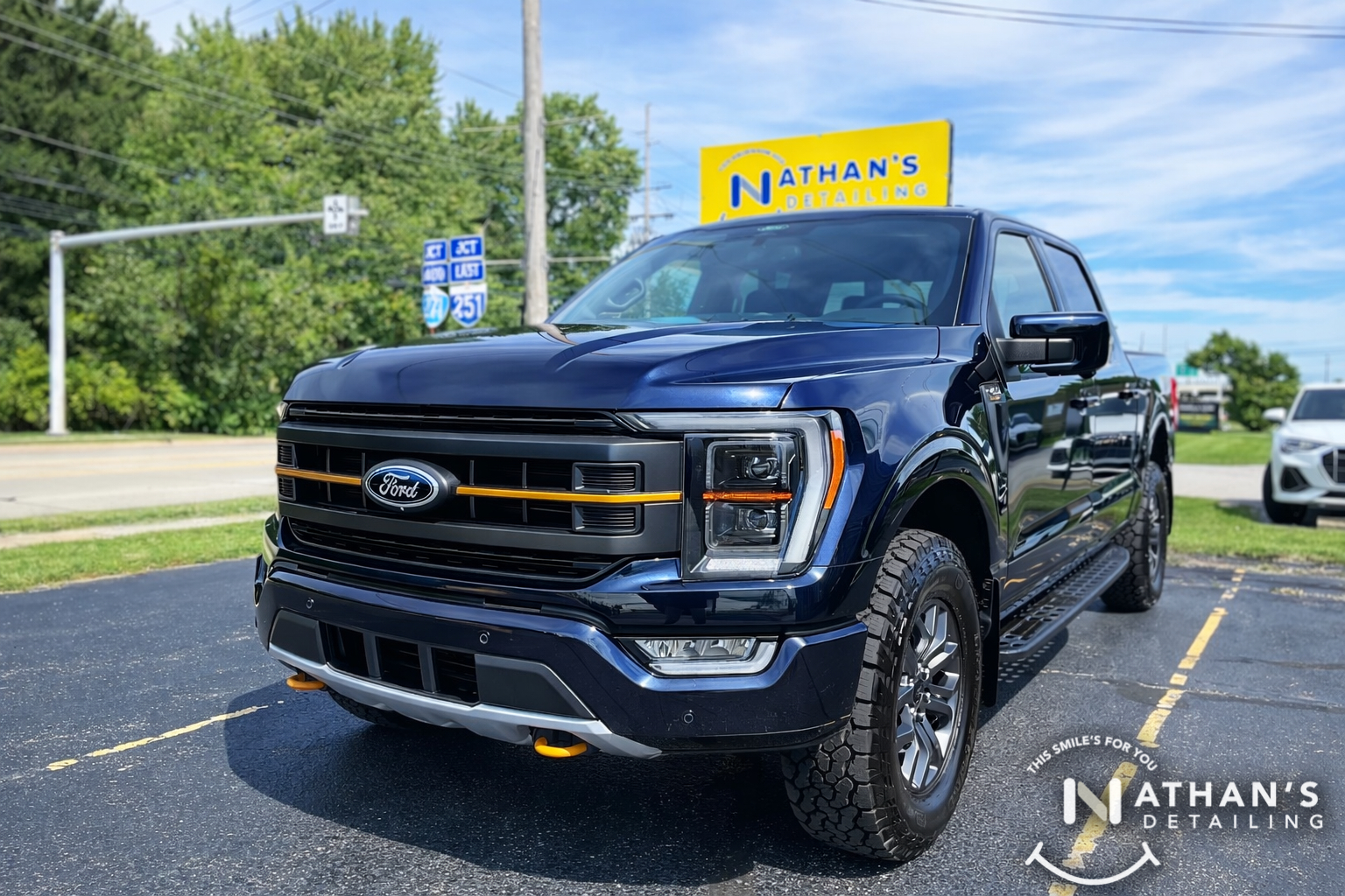 A dark blue Ford F-150 truck displaying a brilliant, wet-look shine following a full ceramic coating application.