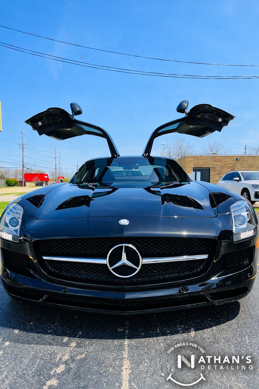 Black Mercedes sports car with gullwing doors shown with a glossy ceramic-coated finish.