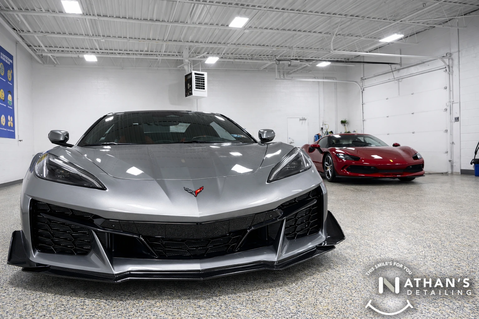 Gray Corvette and Red Ferrari parked in the studio with polished, ceramic-coated shine.