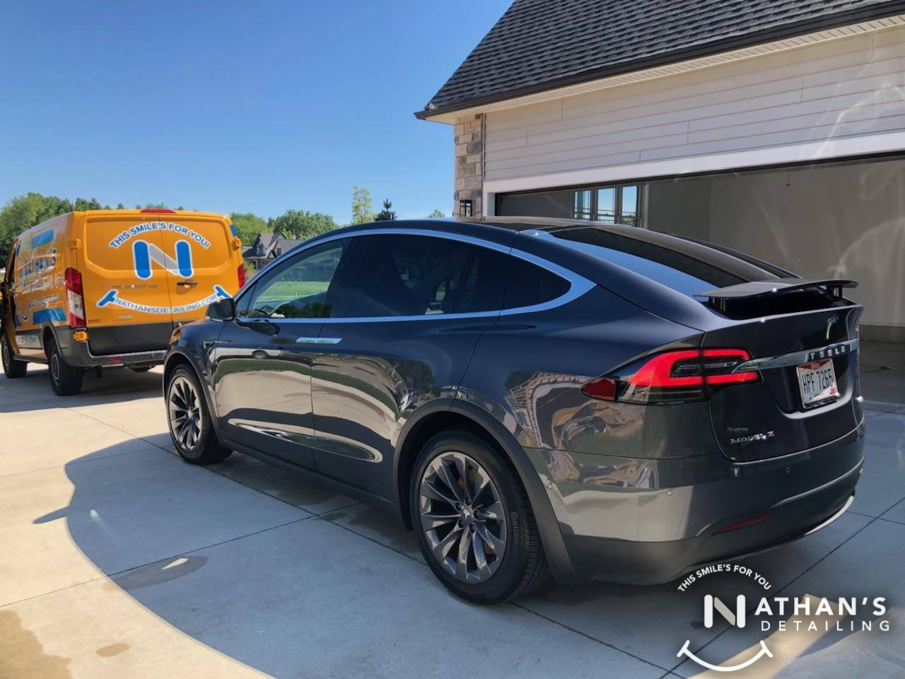 Mobile detailing van behind clean black suv