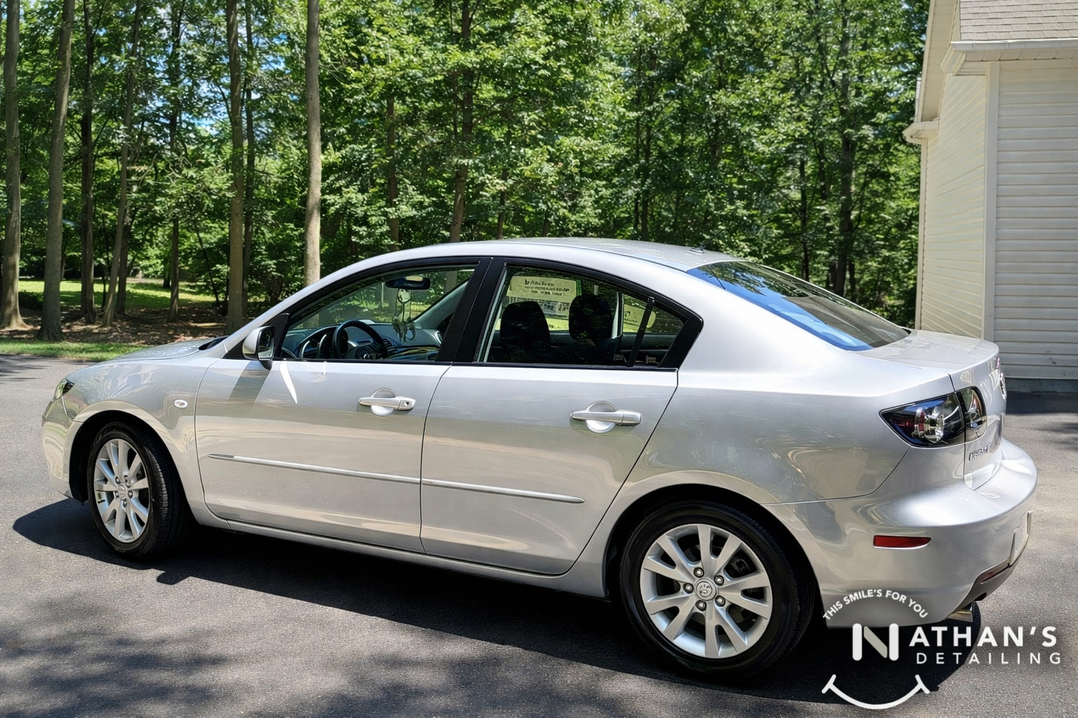 Silver sedan clean side profile curbside during mobile detailing