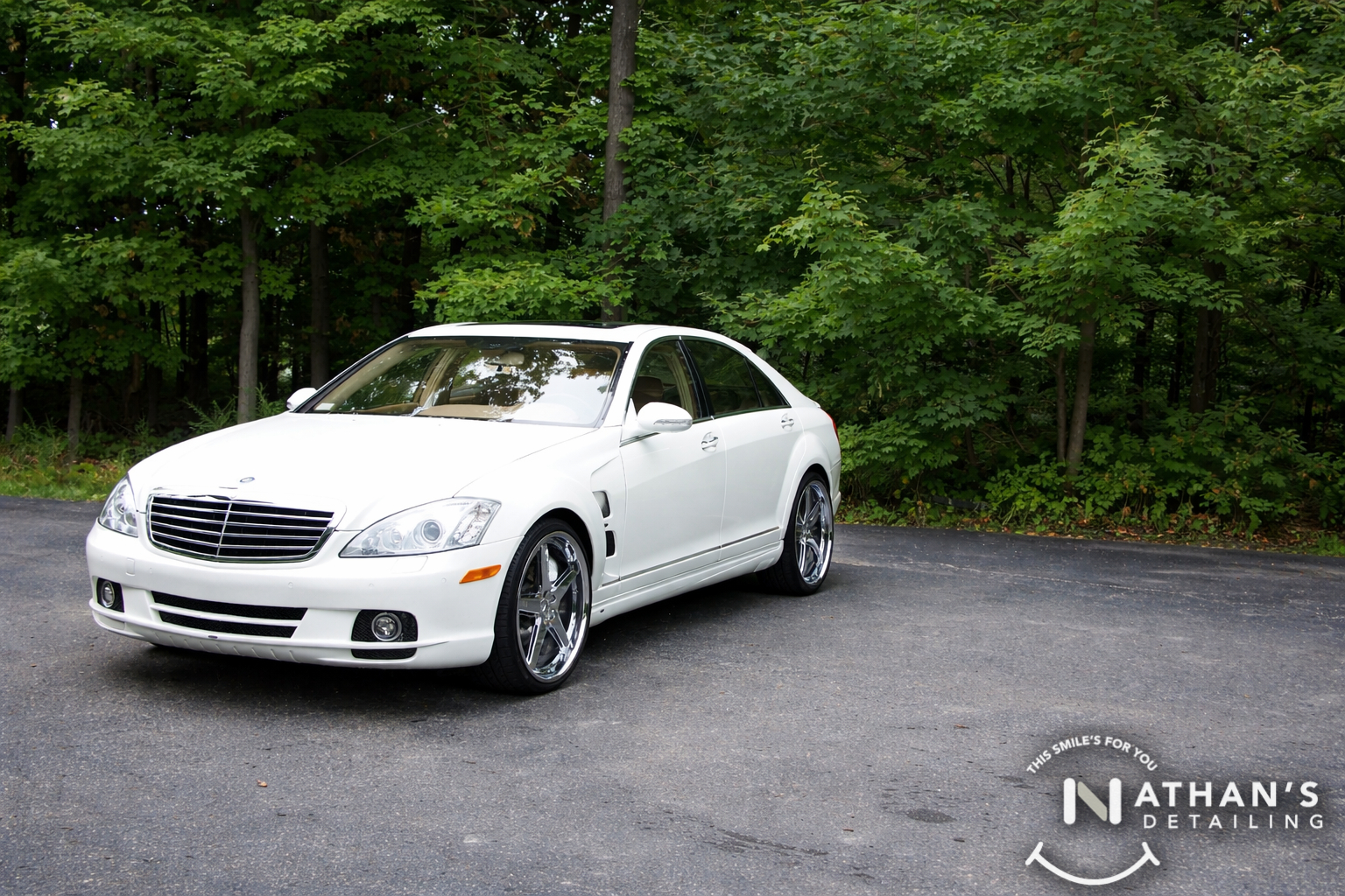 White sedan cleaned with chrome wheels during mobile detailing