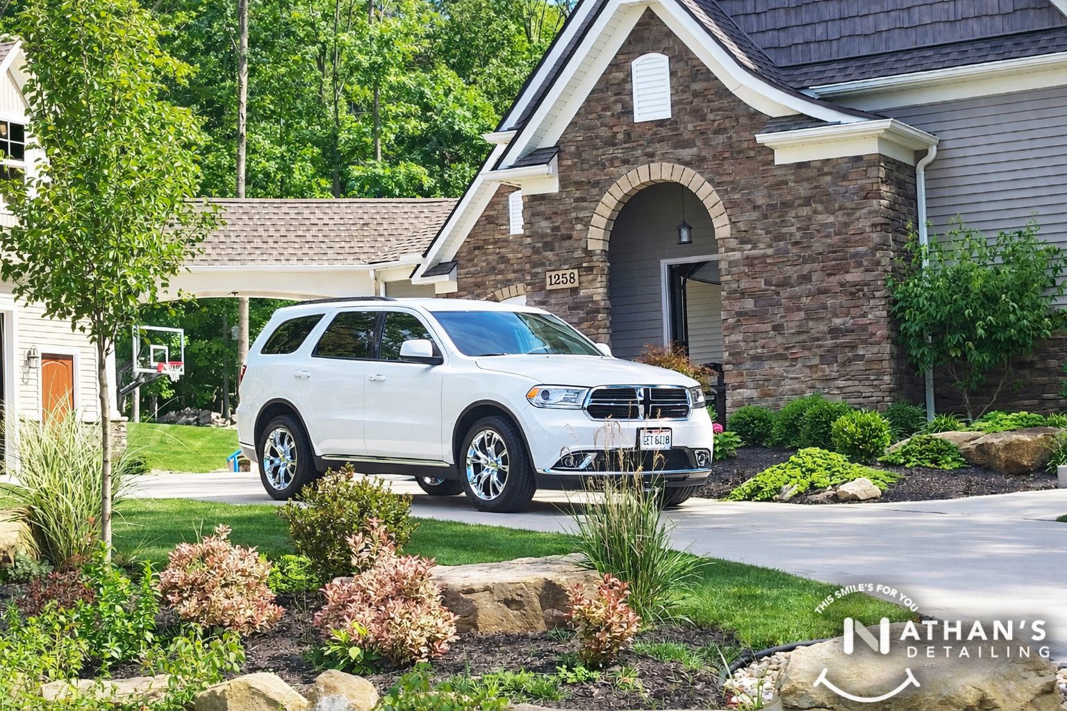 White suv clean exterior by front landscaping during mobile detailing