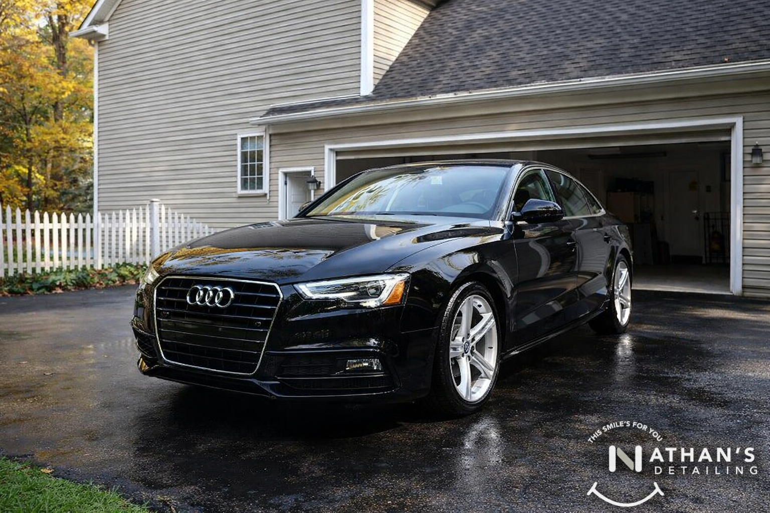 Black audi sedan wet driveway shine during mobile detailing