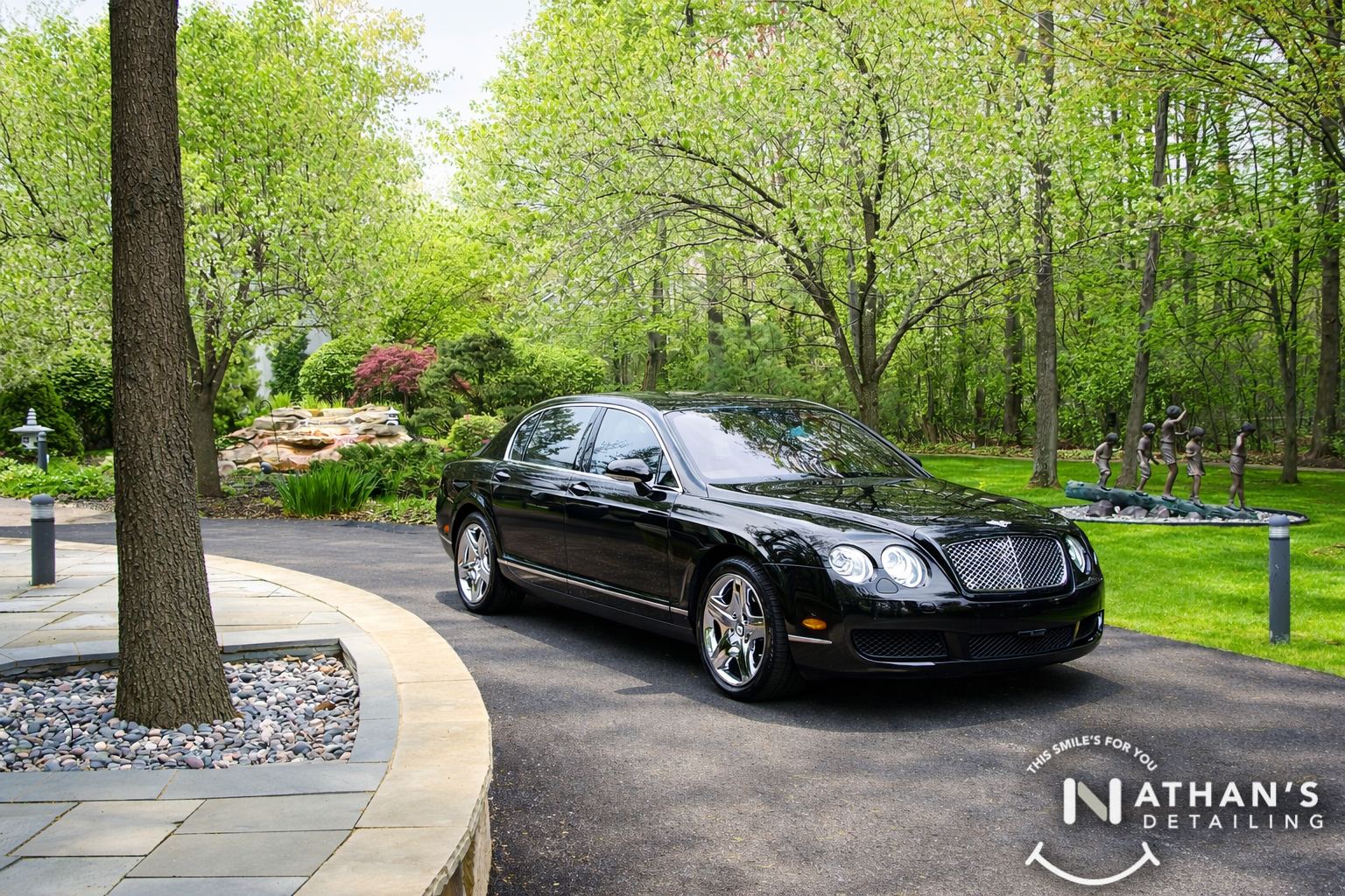 Black bentley sedan clean finish on driveway during mobile detailing