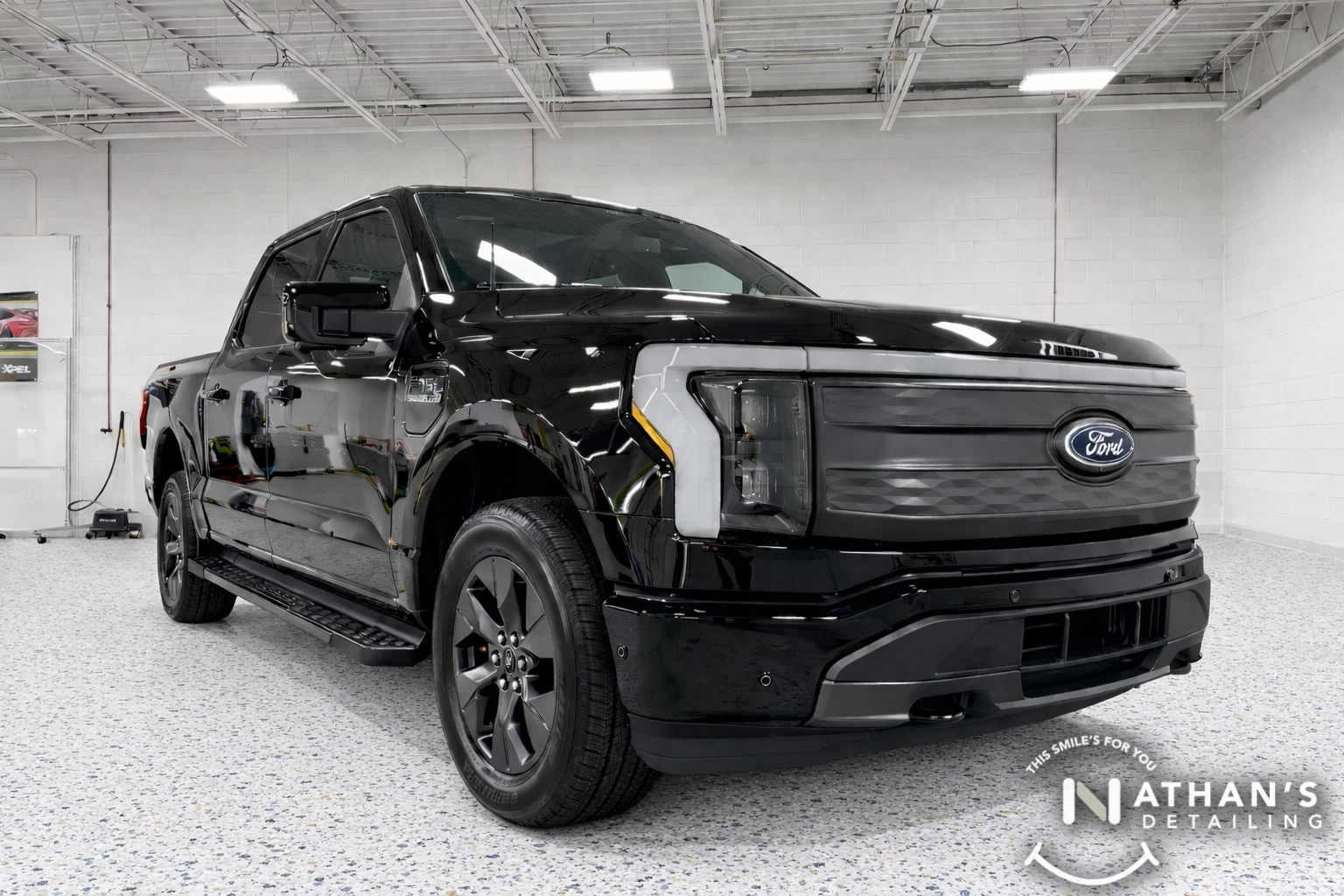 Black Ford F-150 displayed inside the shop after paint protection film protection.