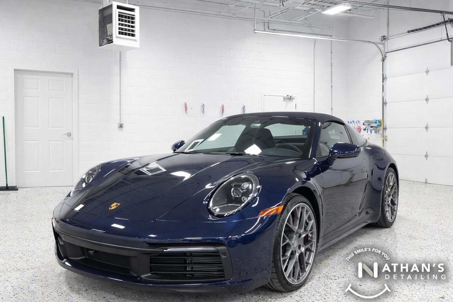 Blue Porsche 911 in the shop after paint protection film installation.