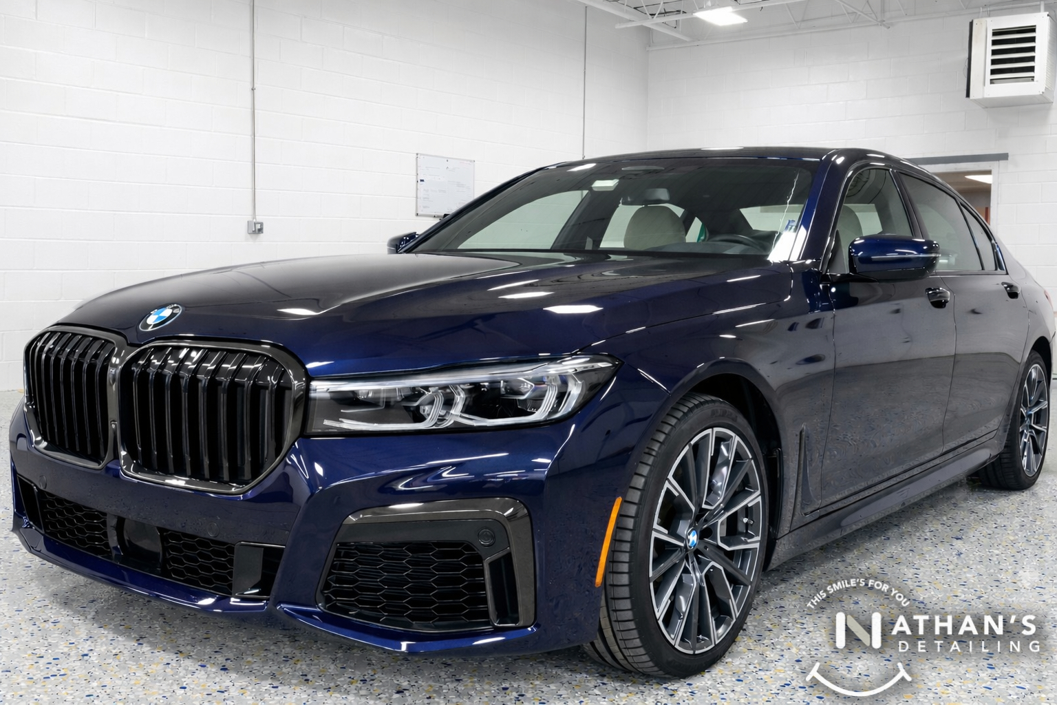 Dark blue BMW sedan in the shop with a glossy ceramic-coated finish.