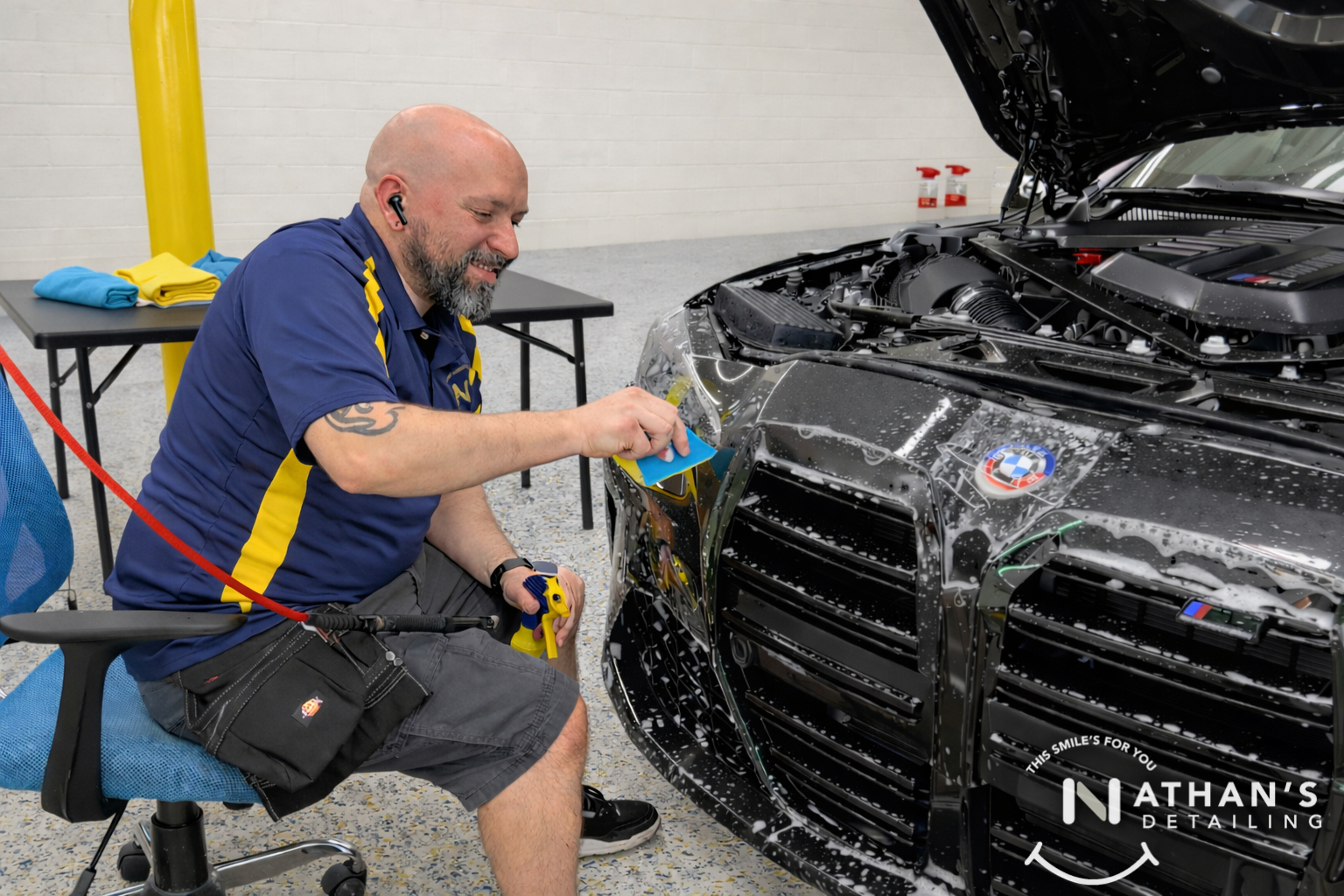 Installer spraying slip solution while applying paint protection film to a truck front end.