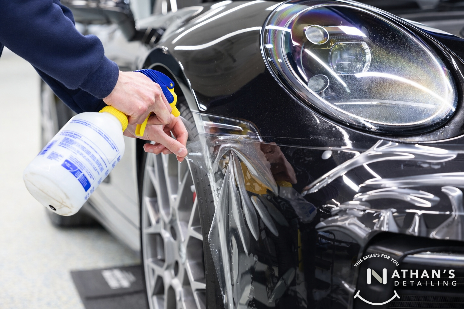 Close-up of slip solution sprayed on paint protection film near a Porsche headlight in Chagrin Falls, Ohio.